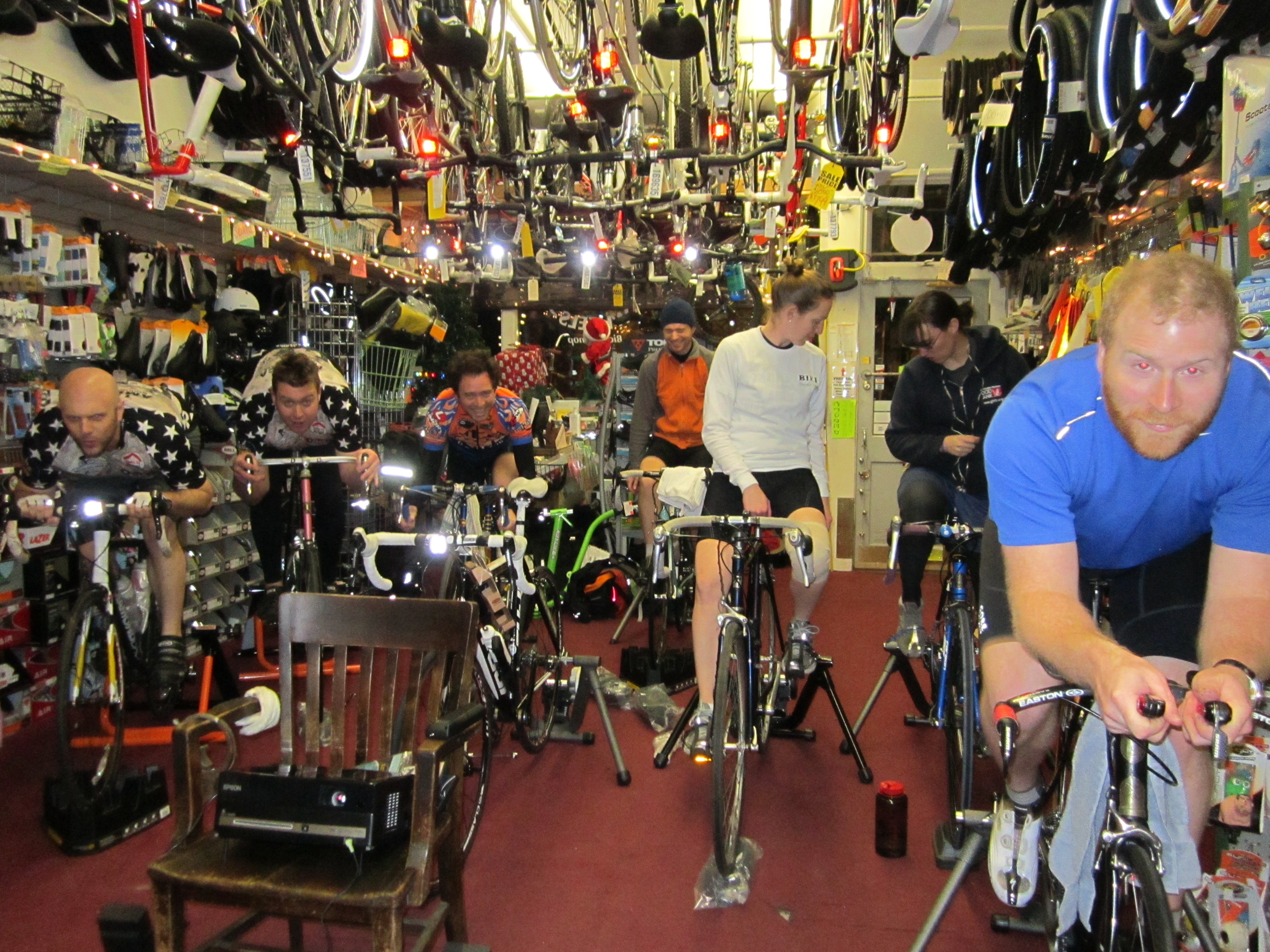 [cyclists on trainers inside the shop]